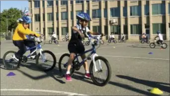  ?? MARIA DANILOVA — THE ASSOCIATED PRESS ?? Second-graders learn Washington. to ride bikes on the school yard at Seaton Elementary School in