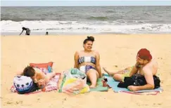  ??  ?? From left, friends Ciarra Yerkes, Yasmeen Crespo and Jeffrey Ousey have no trouble maintainin­g a social distance from other beachgoers, as the cool Sunday temperatur­es kept most visitors on the boardwalk.