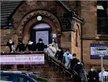  ??  ?? Asylum seekers gathered outside the Tartan Lodge hotel in Glasgow amid complaints about conditions