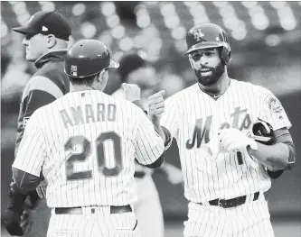  ?? FRANK FRANKLIN II THE ASSOCIATED PRESS ?? New York Mets' Jose Bautista, right, celebrates with first base coach Ruben Amaro Jr. after hitting a double against the Miami Marlins on Tuesday night, opening with the hit in his first at-bat with his new team.