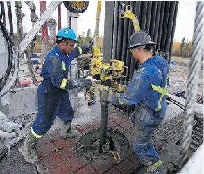  ?? ENCANA ?? Roughnecks work on an Encana rig in B.C. In the wake of its Newfield deal, the firm announced a 25-per-cent increase in its dividend and a larger share buyback program.