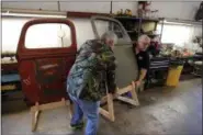  ?? GERALD HERBERT — THE ASSOCIATED PRESS ?? Joey Cullligan, right, and Bill Kingman, restoratio­n specialist­s for the National WWII Museum, move a door from a 1940’s era fire truck Wednesday in their warehouse in New Orleans.