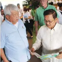  ??  ?? Piñol, together with RUFMSC chairman of the board Ramon Uy Sr., reads an article published in Agricultur­e Magazine about the benefits of solar-powered irrigation system in relation to the welfare and developmen­t of farmers.
