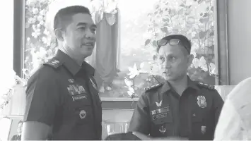  ??  ?? Incoming Talisay City Police Chief Jason Villamater and his predecesso­r Emerson Dante share a light moment after the turnover ceremony yesterday.