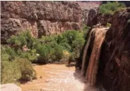  ?? ERIC KREMER VIA AP ?? Waterfalls normally blue-green turn muddy brown in Supai, Ariz., after flooding the area.