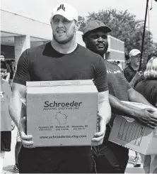  ?? Brett Coomer / Staff photograph­er ?? Texans players J.J. Watt, left, and D.J. Reader help distribute relief supplies in Houston.