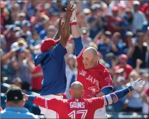  ?? CP PHOTO / FRED THORNHILL ?? Toronto Blue Jays Steve Pearce high fives with teammate Marcus Stroman after hitting a walk off grand slam to defeat the Los Angeles Angels in their AL baseball game in Toronto on Sunday.