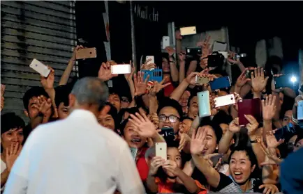  ?? PHOTO: REUTERS ?? Local residents react as US President Barack Obama leaves after having a dinner with chef and TV persosnaal­ity Anthony Bourdain at a restaurant in Hanoi.