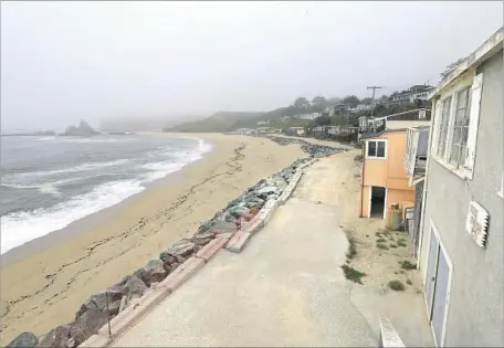  ?? Allen J. Schaben Los Angeles Times ?? COTTAGES overlook Martins Beach, where billionair­e Vinod Khosla has blocked the only road to the sand. An appeals panel upheld a lower court’s order that Khosla unlock the gate to the road, but he is expected to take the fight over public beach entry...