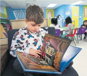  ?? RICHARD LAUTENS TORONTO STAR ?? At the After Four program, run by the Cabbagetow­n Youth Centre, Remi, 5, enjoys reading time.