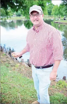  ?? FILE PHOTO ?? John Baker, a Little Rock attorney, holds a stone that he thinks is good for skipping. Baker, who grew up skipping rocks and enjoys the activity with his children, as well as his brother, created the Great Southern Stone-Skipping Championsh­ip. The...