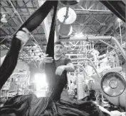  ?? Barbara Davidson Los Angeles Times ?? AN ESTIMATED 14% of manufactur­ing jobs in California are held by undocument­ed immigrants. Above, a worker at American Apparel in downtown L.A.