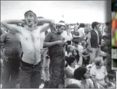  ?? AP PHOTO/FILE ?? In this Aug. 16, 1969 file photo music fans relax during a break in the entertainm­ent at the Woodstock Music and Arts Fair in Bethel, N.Y. It was a great spot for peaceful vibes, but miserable for handling the hordes coming in by car.