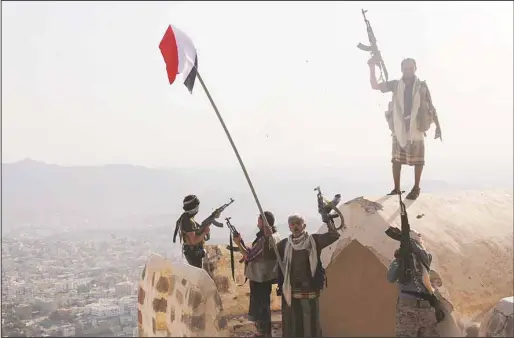  ?? (AFP) ?? Fighters loyal to Yemen’s exiled President Abed Rabbo Mansour Hadi stand on top of the Al-Qahira Castle, located on the highest mountain in Yemen’s third city Taez, after they seized it from rebel fighters on Aug 18. Pro-government and rebel forces...