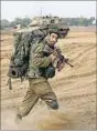  ??  ?? (Left) An Israeli soldier walks outside the Gaza Strip on Saturday; Malaysian activists during a protest calling for an end to Israel’s military offensive at Independen­ce Square in Kuala Lumpur.