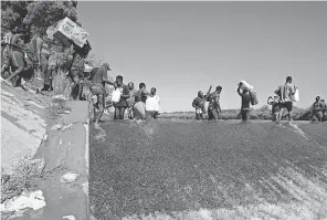  ?? ERIC GAY/ AP ?? Haitian migrants use a dam to cross between the USA and Mexico on Sept. 17 in Del Rio, Texas. Thousands of them assembled under a bridge.