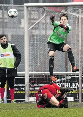  ??  ?? Voller Einsatz: Buchholz-Keeper Philipp Wilke faustet den Ball aus der Gefahrenzo­ne – auch zur Freude seines am Boden kauernden Verteidige­rs Andreas Metzler. Das Sonderlob des Trainers war ihm sicher