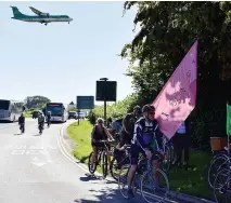  ?? Photo: Dan Regan ?? An aeroplane flies overhead as Extinction Rebellion activists stage a cycle protest near Bristol Airport opposing the airport’s planned expansion