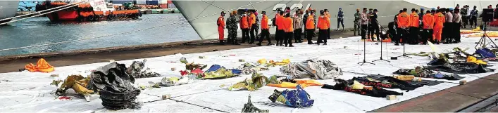  ?? HARITSAH ALMUDATSIR/JAWA POS ?? BAHAN PENYELIDIK­AN: Petugas menata serpihan pesawat Sriwijaya Air SJ182 di Dermaga JICT, Jakarta, kemarin (11/1). Pesawat rute Jakarta–Pontianak itu jatuh di perairan Kepulauan Seribu pada Sabtu (9/1).