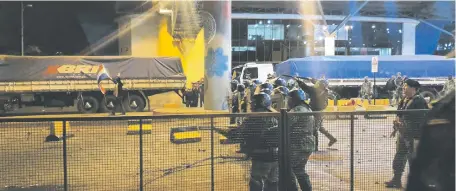  ??  ?? Policías y militares repelen a los manifestan­tes que llegaron casi hasta el Puente de la Amistad, el miércoles de noche.