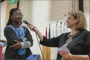  ?? The Sentinel-Record/Grace Brown ?? CITIZENSHI­P BEE: Langston Leadership Academy fourth-grader Reginea Floyd, left, answers a civics question during Langston’s third annual Citizenshi­p Bee in the school’s gym Thursday. Principal Eileen Ellars, right, quizzed students over questions from the U.S. citizenshi­p test in eliminatio­n rounds.