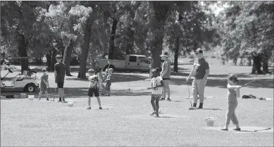  ?? Michael Burchfiel/Siloam Sunday ?? Kids practiced hitting with long irons as part of a fundamenta­l golf camp this week at the Siloam Springs Country Club.