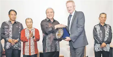  ??  ?? Awang Tengah presents Wilson (second right) with a token of appreciati­on. Also seen are (from left) Dr Abdul Rahman, Naroden and Dr Penguang. — Photo by Chimon Upon