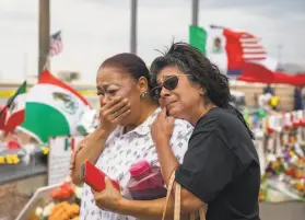  ?? Calla Kessler / New York Times ?? Laura Caballero (right) embraces a fellow community member Tuesday at a memorial outside the Walmart in El Paso, Texas, where 22 people were killed.