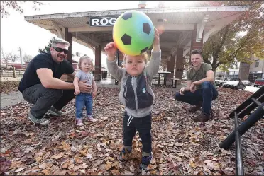  ?? NWA Democrat-Gazette/FLIP PUTTHOFF ?? Thompson Lockwood, 1, is the soccer star Saturday while playing at Frisco Park in Rogers with his dad, Lance Lockwood (right), Matt Burgess (left) and Zoe Burgess, 1. Frisco Park is being redesigned and will be renamed Railyard Park.