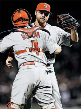  ?? JOHN G. MABANGLO/EPA ?? Closer Trevor Rosenthal and catcher Yadier Molina celebrate the Cards’ win Thursday.