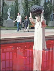  ?? AP-Czarek Sokolowski ?? Visitors to the National Museum stop before a new statue of the late pope, St. John Paul II, throwing a stone at a “Poisoned Well” just hours before its official inaugurati­on in the museum yard in Warsaw, Poland, on Sept. 24. The sculpture by Poland’s Jerzy Kalina is said to be a response to a controvers­ial 1999 sculpture by Italian Maurizio Cattelan in which the Polish-born pontiff was shown as being crushed by a similar stone.