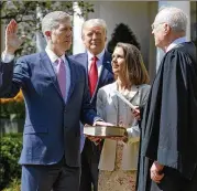  ?? AP 2017 ?? President Donald Trump watches as Supreme Court Justice Anthony Kennedy administer­s the judicial oath to Judge Neil Gorsuch during a re-enactment in the Rose Garden of the White House last year. Trump has said he would replace Kennedy with a judge is more consistent­ly conservati­ve on social issues.