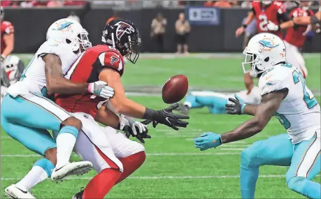  ?? File, Curtis Compton / Atlanta Journal-Constituti­on via AP ?? Miami’s Cordrea Tankersley (left) hits Atlanta’s Austin Hooper (center) knocking the ball loose for a intercepti­on by Reshad Jones during Sunday’s game.