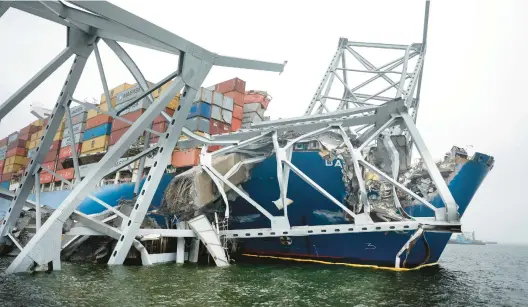  ?? CHIP SOMODEVILL­A/GETTY ?? The wreckage of the Francis Scott Key Bridge remains twisted around the bow of the container ship Dali on Tuesday in Baltimore, Maryland.