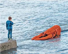  ??  ?? A boy in Staithes, North Yorkshire, inspects a giant model lobster at the annual art festival