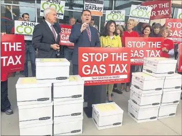  ?? JULIE WATSON — THE ASSOCIATED PRESS ?? Republican gubernator­ial candidate John Cox, left, and gas tax repeal organizer Carl DeMaio, center, stand Monday in front of 15 boxes of signed petitions outside the San Diego Registrar of Voters building before submitting them.