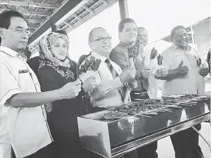  ?? — Gambar Bernama ?? PERTAMA DI MALAYSIA: Pengurus Labuan Corporatio­n Advisory Council Datuk Bashir Alias (tiga kanan) menunjukka­n sate tuna, yang pertama di Malaysia dikeluarka­n oleh pengusaha tempatan, Suzanna Ahmad (dua kiri) dibawah bimbingan Jabatan Perikanan Labuan...