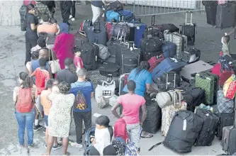  ?? THE CANADIAN PRESS FILES ?? Asylum seekers line up to enter Olympic Stadium on Aug. 4, 2017 near Montreal. The federal government’s contingenc­y plans for a new surge of asylum seekers at the border this winter could be put to the test with the pending decision on the fate of...