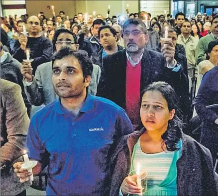  ?? ALLISON LONG / AP ?? Alok Madasani, supervivie­nte del tiroteo, junto a su esposa, embarazada, en una vigilia por el muerto