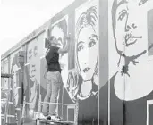  ??  ?? Artist Lori Pratico works on her “Together” mural Thursday in Oakland Park.