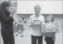  ?? MATHEW MCCARTHY, RECORD STAFF ?? Huron Heights teacher Debbie Dokas, left, watches as Terri Heise, and her daughter, Sophia, get emotional after being given a cheque for more than $10,000 and a good used van from Galt Chrysler.