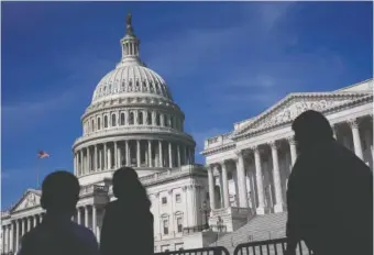  ?? AP FILE PHOTO/PATRICK SEMANSKY ?? People walk outside the U.S. Capitol building in Washington.