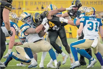  ?? PETER POWER THE CANADIAN PRESS FILE PHOTO ?? Winnipeg Blue Bombers’ Casey Sayles has a firm grip on Tiger-Cats running back Wes Hills in Hamilton last September. The Ticats have signed Sayles to a two-year deal.