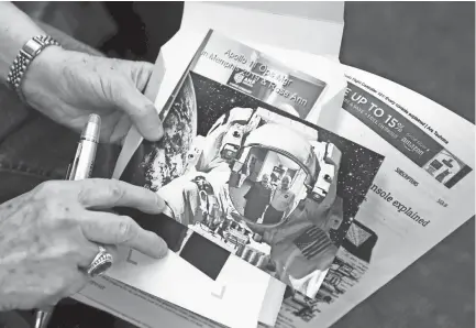  ?? APPEAL ?? Rose Ann Bradley holds a photo of her and Bill Weppner, a former NASA flight controller who worked on the space program's Apollo missions, during his talk at the Germantown library Tuesday, June 18, 2019. JOE RONDONE/THE COMMERCIAL