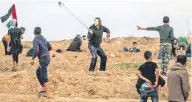  ??  ?? Un manifestan­te palestino lanza piedras contra las fuerzas israelíes, durante la protesta de ayer en Gaza.