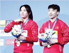  ??  ?? China’s Wang Han and China’s Li Zheng pose with the gold medal during the podium ceremony for the Mixed 3m synchro springboar­d final during the diving competitio­n at the 2017 FINA World Championsh­ips in Budapest, on July 22, 2017. - AFP photo