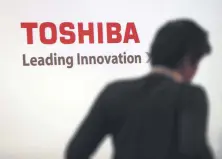  ??  ?? A man walks past the logo of Toshiba Corp. displayed at the company’s headquarte­rs in Tokyo.