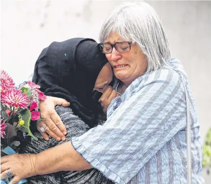  ?? PHOTO: REUTERS ?? Tears: Women embrace near Al Noor mosque in Christchur­ch, New Zealand.