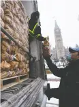  ?? ADRIAN WYLD / THE CANADIAN PRESS FILES ?? Bags of P.E.I. potatoes are unloaded in December near Parliament Hill in Ottawa.