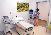  ??  ?? Esther Otero, a nurse in the adult medicine department, prepares an exam room at the new clinic near the Albuquerqu­e Sunport.